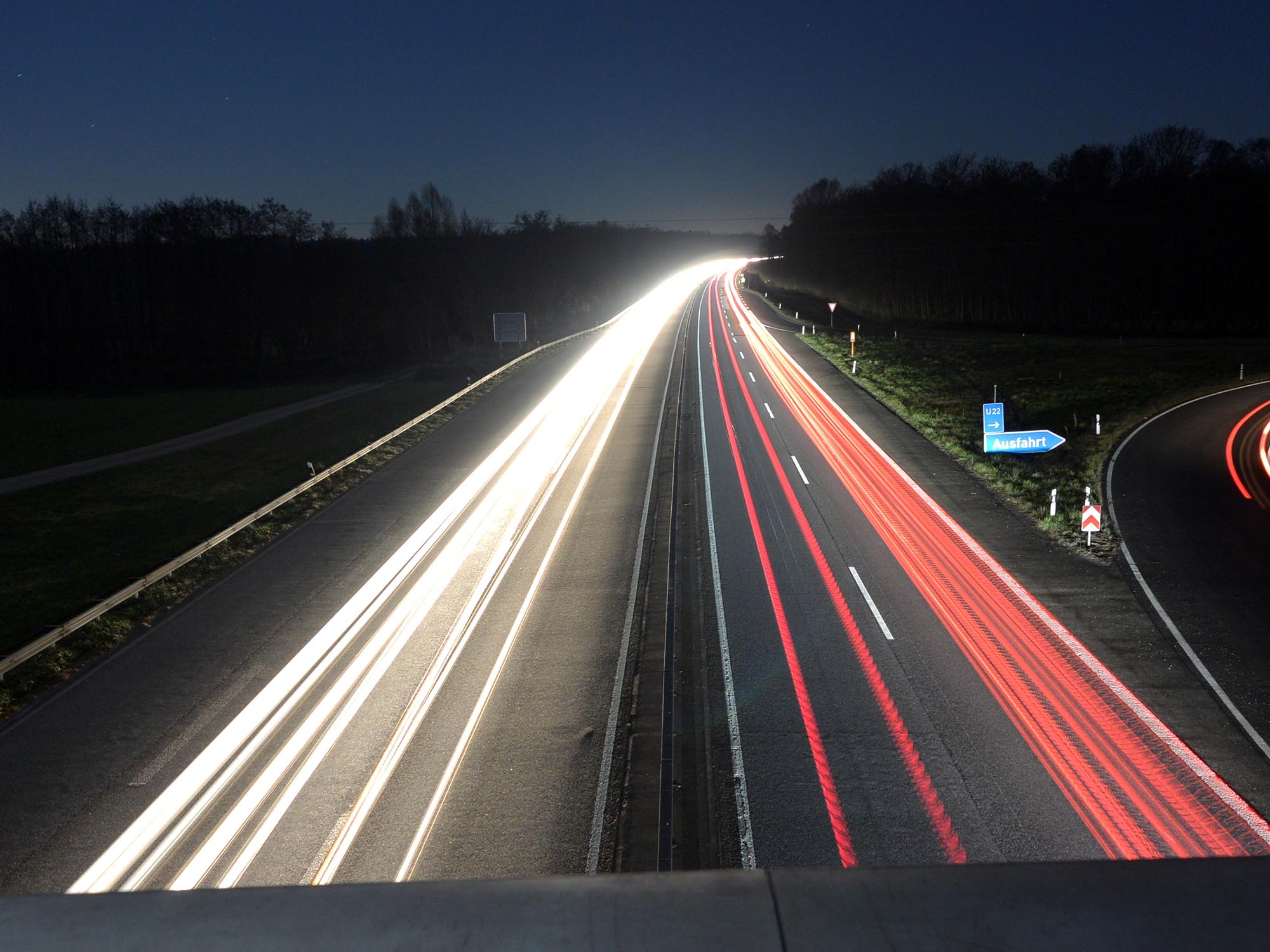 Kuva moottoritieltä pimeässä, jossa näkyy autojen valot